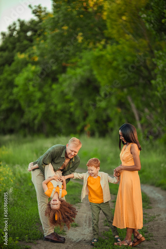 Happy international family on a summer walk in the park.