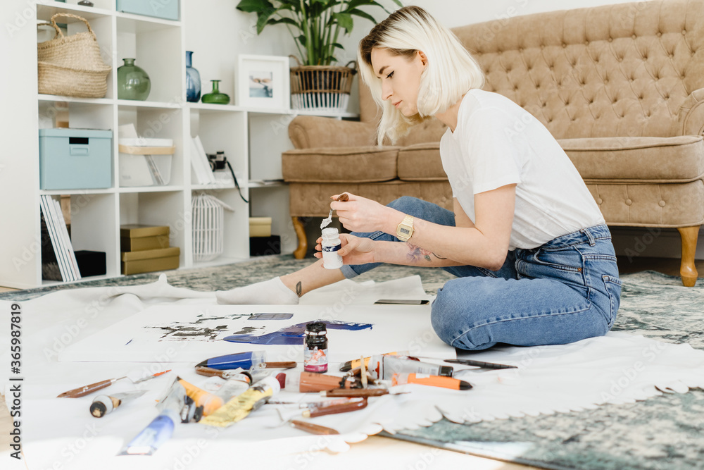 Beautiful young woman artist drawing in a comfy home interior Beautiful young woman artist drawing in a comfy home interior