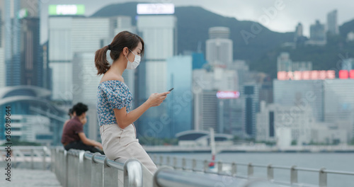 Photography Woman wear face mask and use of mobile phone in Hong Kong