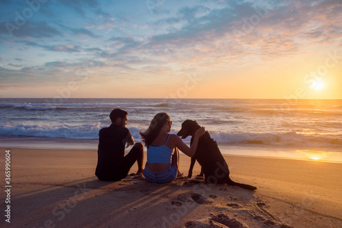 pretty young couple on the beach at sunset