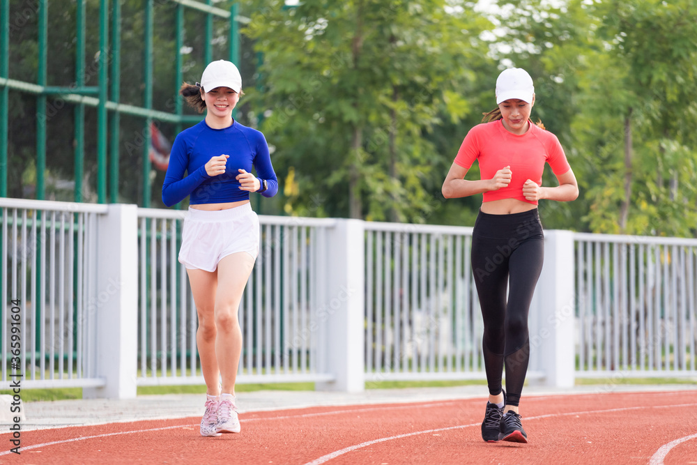 Obraz premium Young fitness woman runner jogging excercise in the morning on city stadium track in the city. Female athlete excercise in the city stadium to keep body fitness. Stock photo.