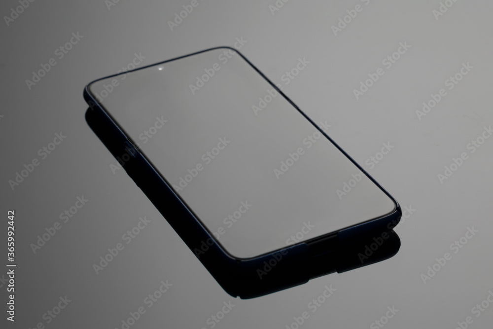 Black large screen smartphone with shadow on glass surface