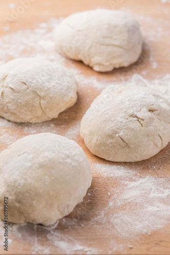 Freshly prepared yeast dough for pizza or bread on wooden background.