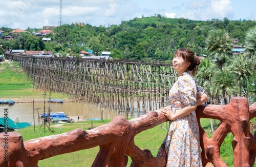 Cute asian woman wear casual posting alone on wooden bridge at Sangkhaburi, Kanchanaburi, Thailand.