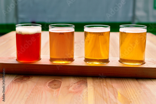 Beer tasting. Diferent beer in 100 mililiter glases over wooden table.