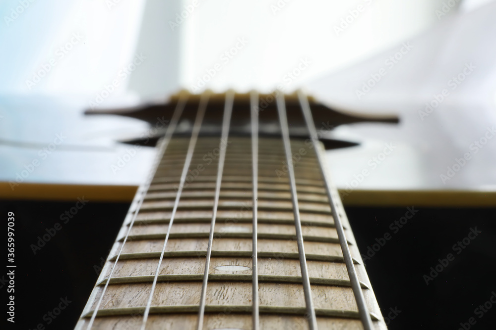 Fototapeta premium An acoustic guitar for an artist playing a stringed musical instrument on stage. Black guitar with a capo. Musical background.