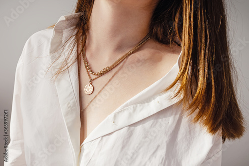 Fototapeta Close-up young woman in white shirt wearing golden necklaces