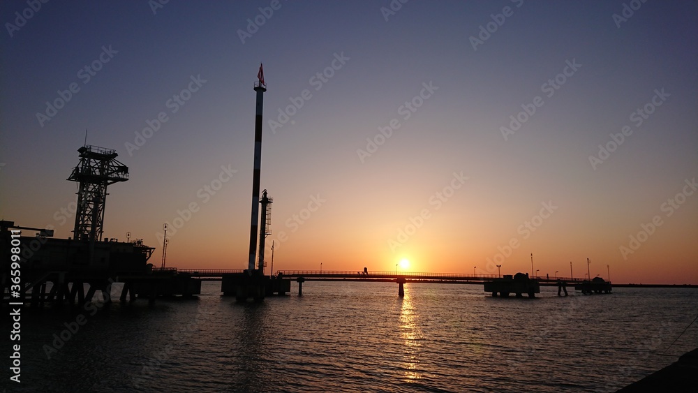 海上のオイルターミナルと夕焼け/Oil terminal at sunset over the sea