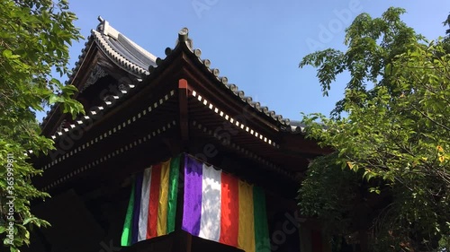 Kobuchi Kannon Temple's roofs and colorful curtains with blue sky and green trees. Kasukabe, Saitama, Japan, July 20, 2020 photo