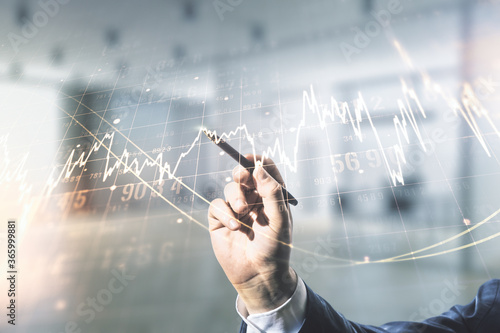 Multi exposure of analyst hand with pen working with virtual abstract financial diagram on blurred office background, banking and accounting concept