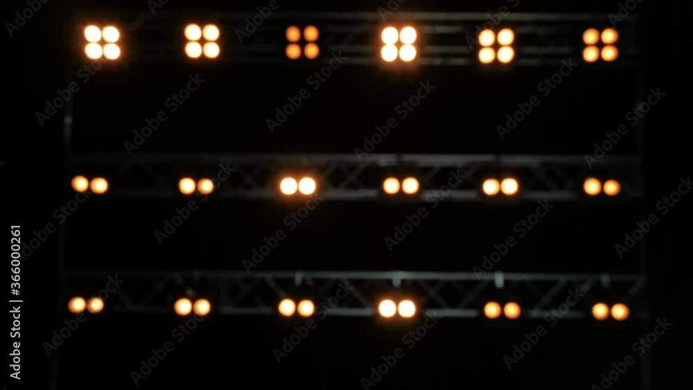 Blurred background of yellow lghts. Lights on the black stage. Blurred background of yellow lghts. Lights on the black stage.