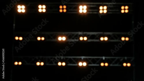 Blurred background of yellow lghts. Lights on the black stage. photo