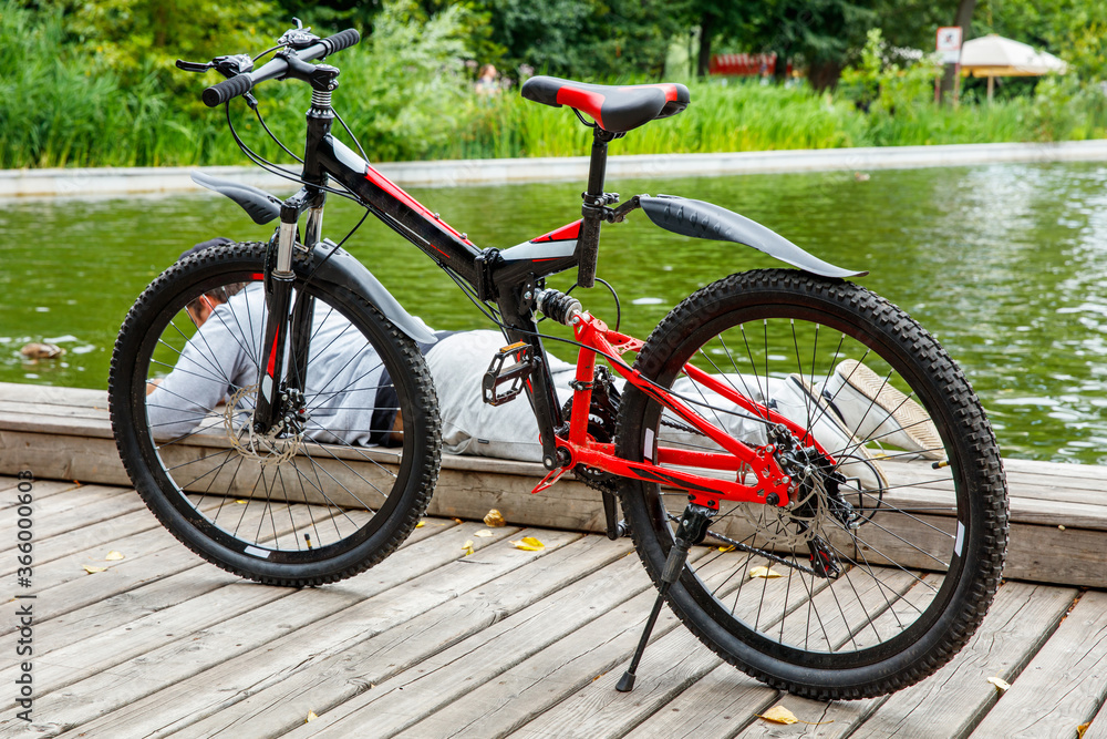 The guy is resting on a lying on the embankment. In the foreground is a bicycle. The guy is resting on a lying on the embankment. In the foreground is a bicycle.