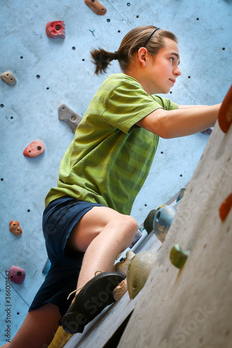 Teenage Boy Training On Climbing Wall
