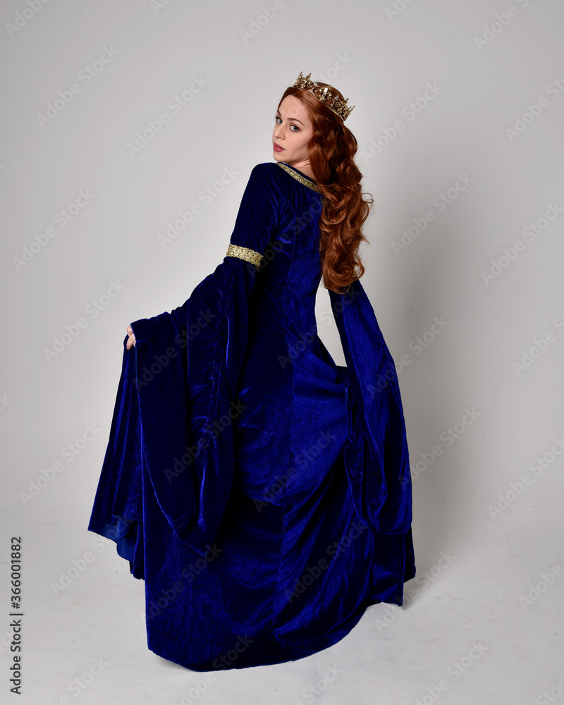 Full length portrait of girl wearing long blue velvet gown with golden ...