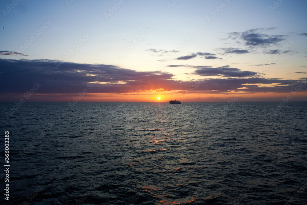 Kreuzfahrtschiff bei Sonnenuntergang im Meer bei Dämmerung 