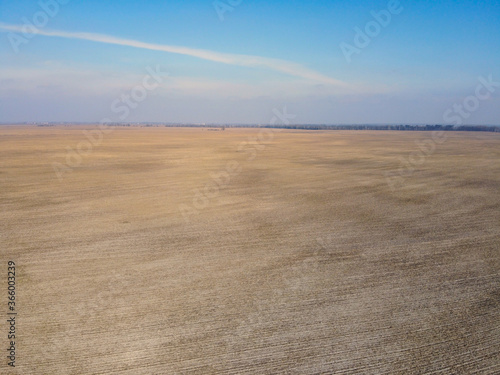 Agricultural fields on a sunny spring day, aerial view. Landscape. Blue sky over the fields.