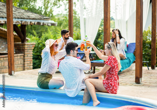 Group of young people having fun at summer vacation and enjoying a poolside party with drinks. © Zoran Zeremski