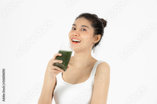 Healthy young Asian woman drinking green detox vegetable smoothie over white isolated background. Vegetarian drink juice, Healthy lifestyle, Fitness and health care concept.