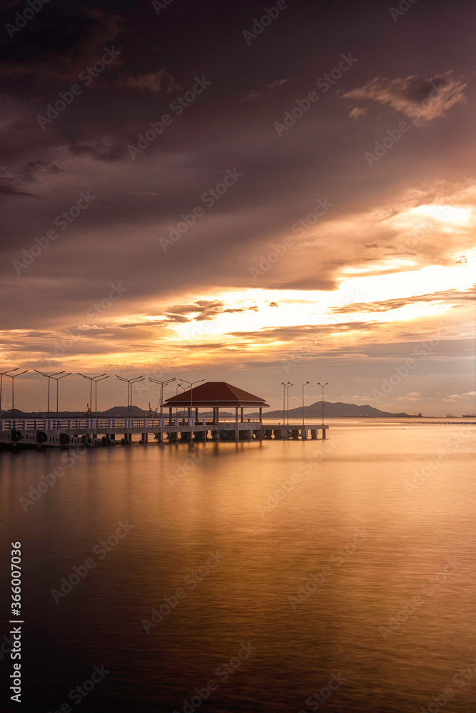 Sunset seascape with bridge and dramatic sky.