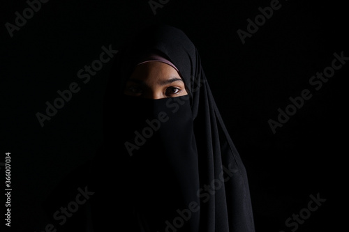 Portrait of Beautiful Muslim Woman in niqab on black background