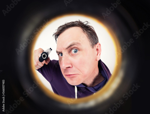 Schilderij op canvas Man with a gun is seen through the peephole