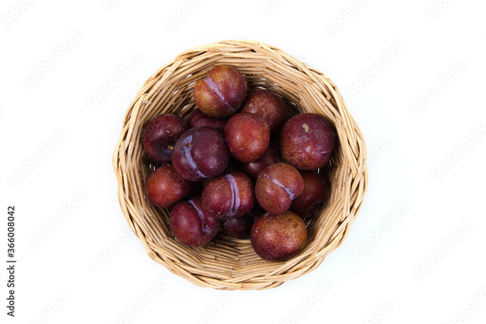 Plums in basket on white background. High angle view of fresh plums. Top view of plums fruit on white background. Plums in basket on white background. High angle view of fresh plums. Top view of plums fruit on white background.