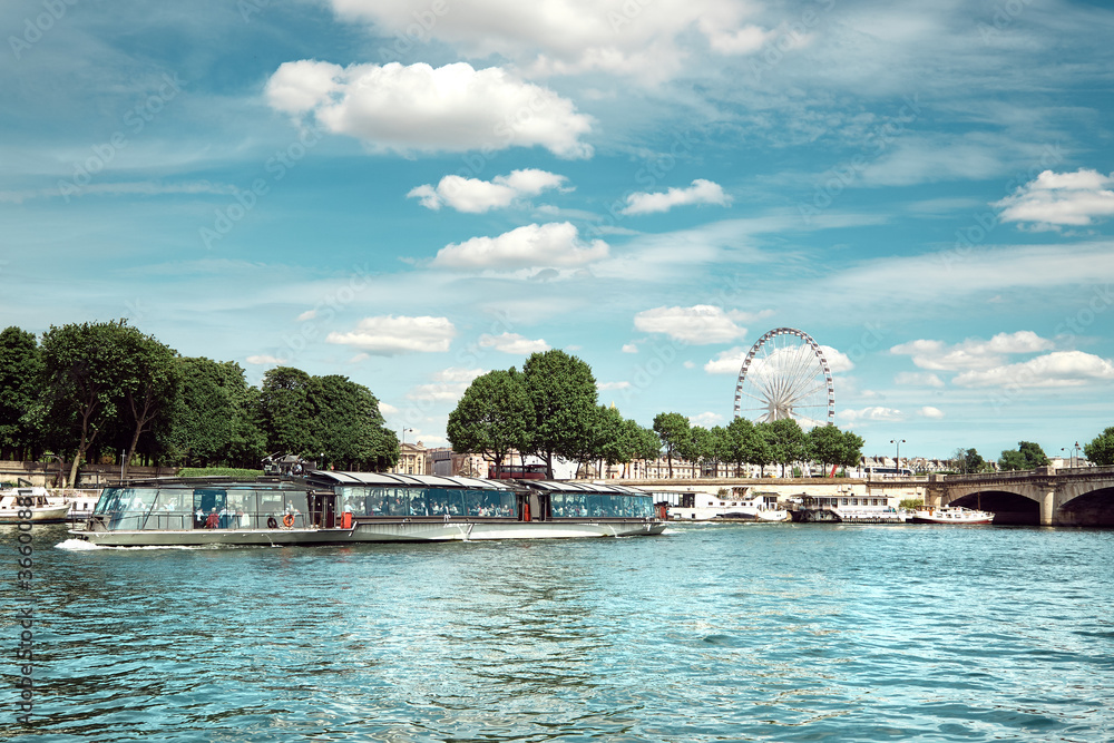 Riverside in Paris with ferris wheel on Concorde and passenger boat