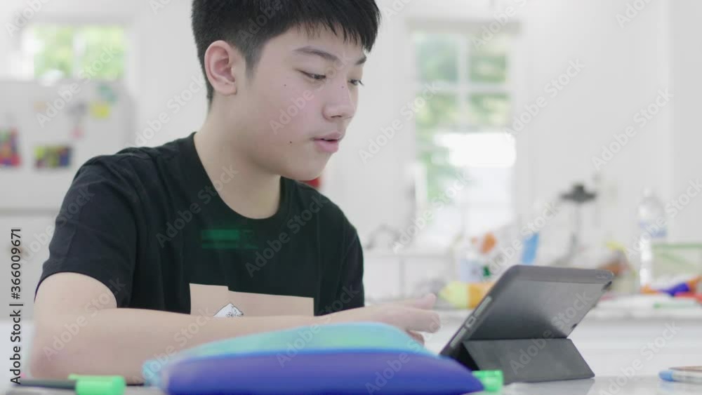 Asian teen student Studying online at home. The boy is interacting with the teacher through online teaching. Asian teen student Studying online at home. The boy is interacting with the teacher through online teaching.