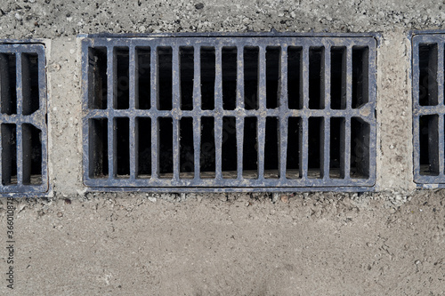 Fotografie New rainwater grate on the road or sidewalk, installation in concrete
