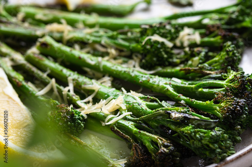 Roasted broccolini with lemon on the plate . Close up angle view. photo