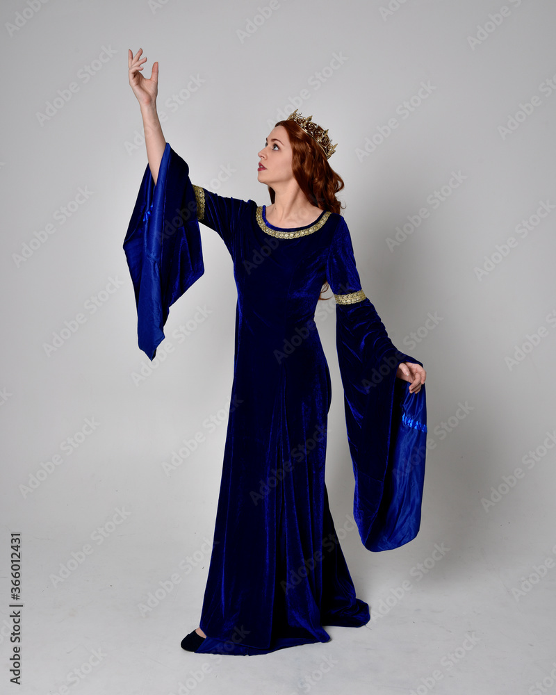 Full length portrait of girl wearing long blue velvet gown with golden ...
