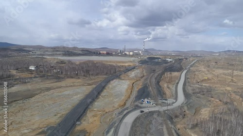 Aerial view of copper plant in Karabash city. Smoke comes out of the chimney. Around the contaminated area. Cars drive on the road. Russia, Chelyabinsk region