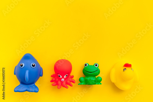 The concept of children’s bath toys. Yellow background top view copyspace
