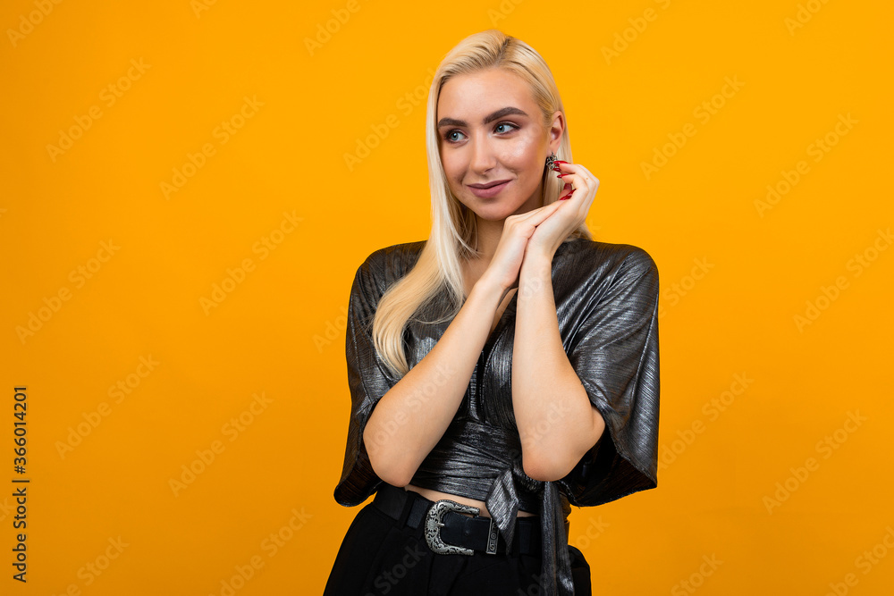 Obraz premium european elegant girl model flirts on a yellow background with copy space