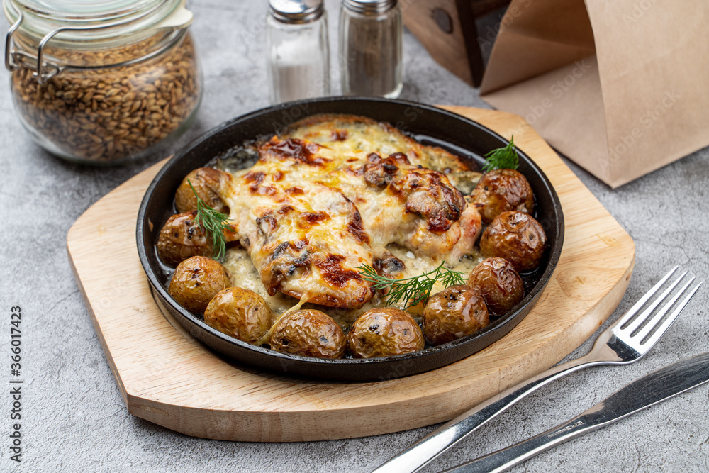Unpeeled baby potatoes with chicken breasts coated in creamy gravy baked and served in cast iron skillet
