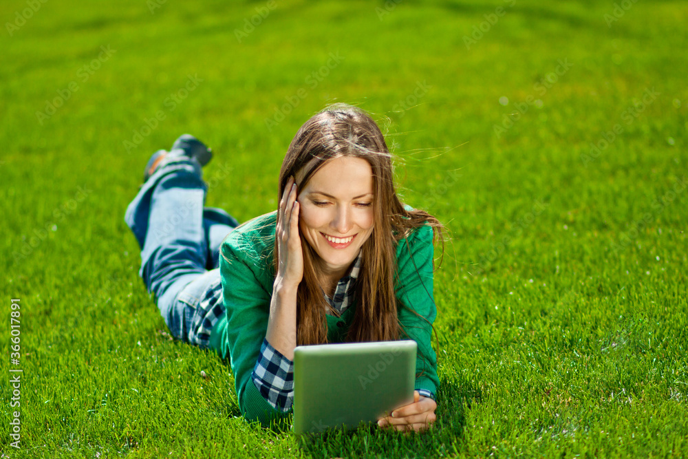 Young woman working on laptop while resting in a city park Young woman working on laptop while resting in a city park