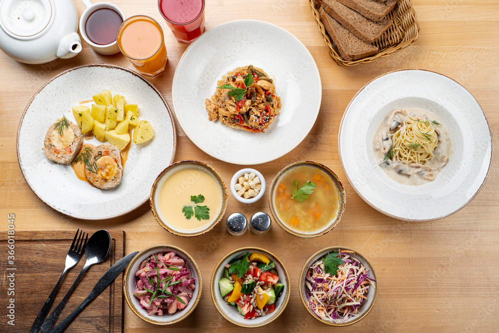Directly above photo of lunch in a cafe, served in wooden table, with various of meals Directly above photo of lunch in a cafe, served in wooden table, with various of meals