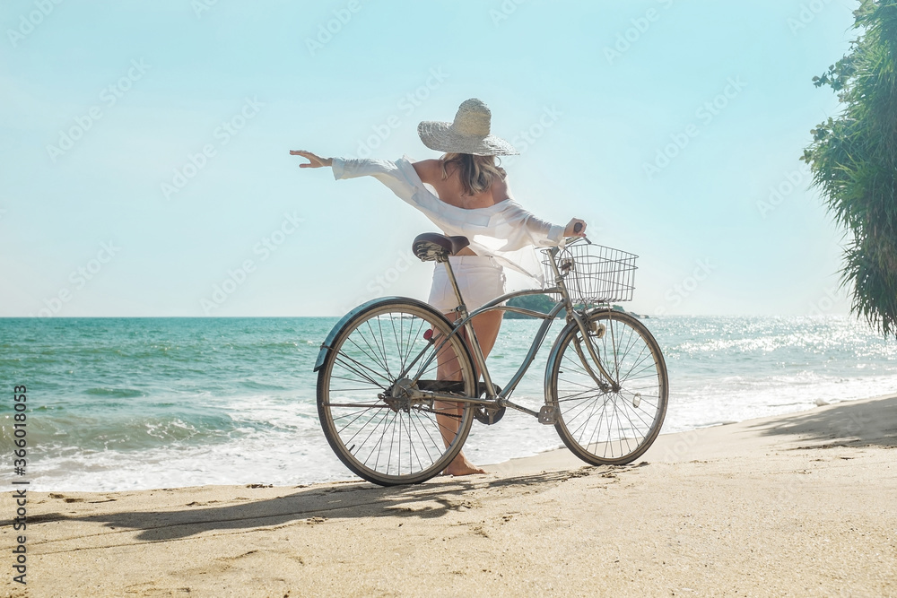 Happiness woman traveler with her bicycle rides on sea coastline Happiness woman traveler with her bicycle rides on sea coastline