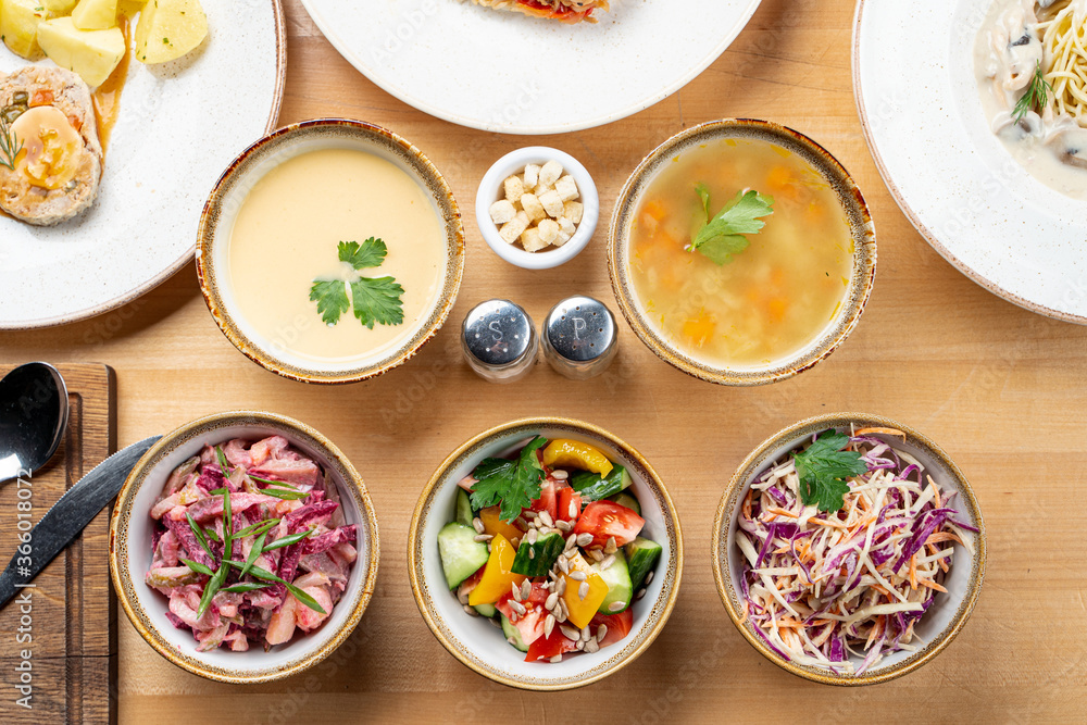 Menu photo of different kinds of salads and soups, directly above studio shot, full table