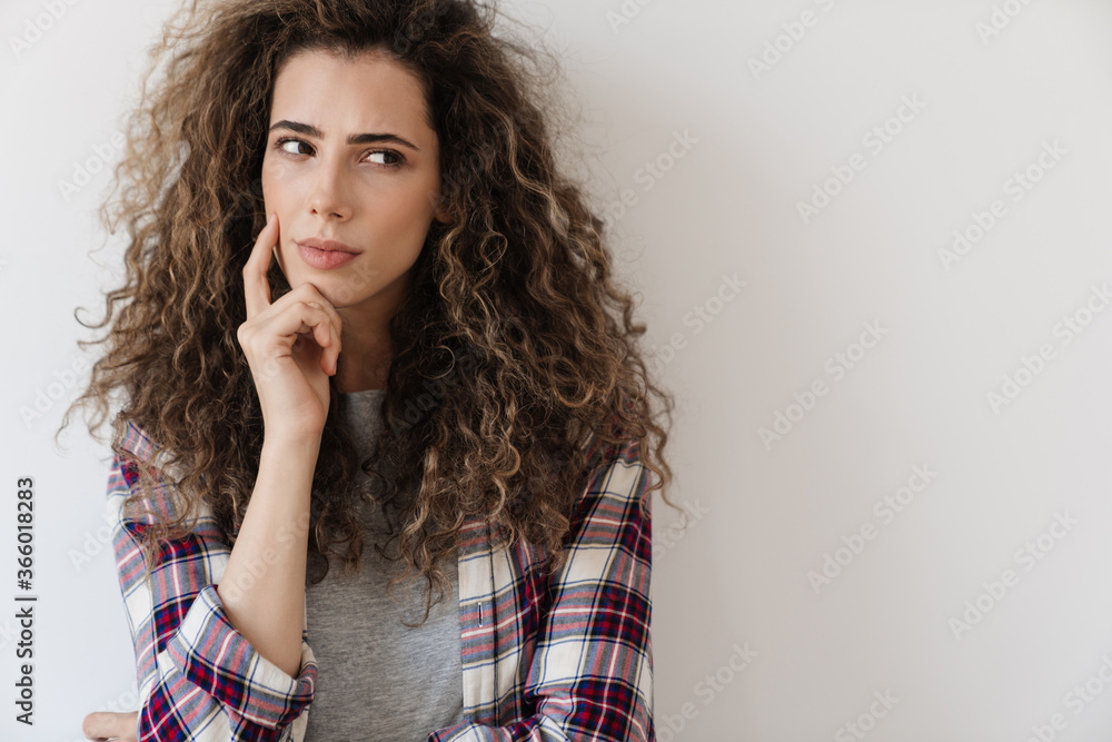 Photo of puzzled beautiful woman looking aside while posing on camera