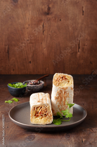 Obraz na płótnie A cut Chicken doner kebab in roll of pita bread lavash. Shawarma Sandwich on a wooden background w salonie