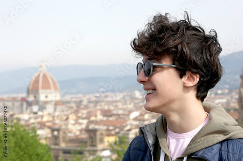 portrait close up of a smiling male teenager with the city of Florence on the background with copy space for your text © Andrea