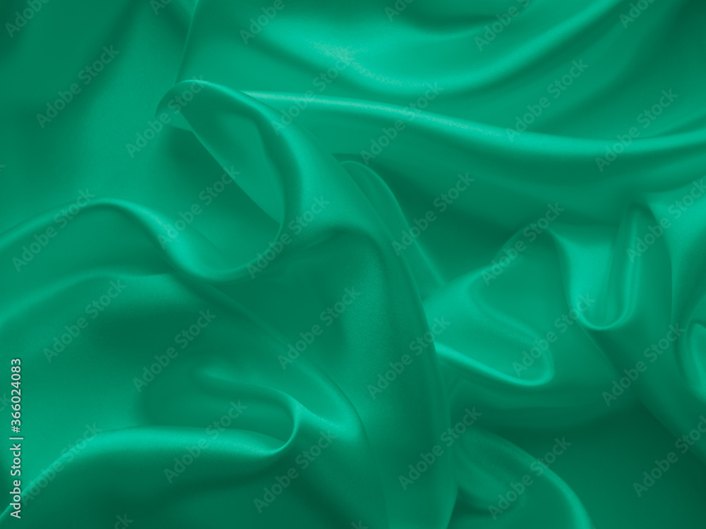 Obraz premium Beautiful elegant wavy emerald green satin silk luxury cloth fabric texture, abstract background design. Card or banner.
