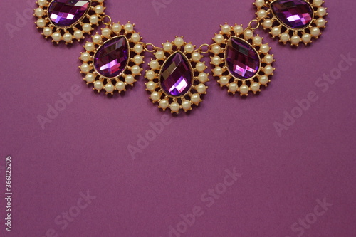luxury purple jewelry in the Baroque style on a purple background. Vintage, retro style. copy space 