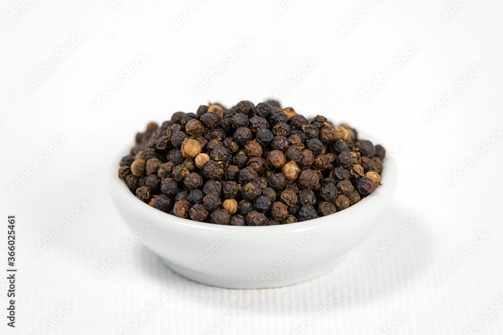 black pepper in white bowl on white canvas background black pepper in white bowl on white canvas background
