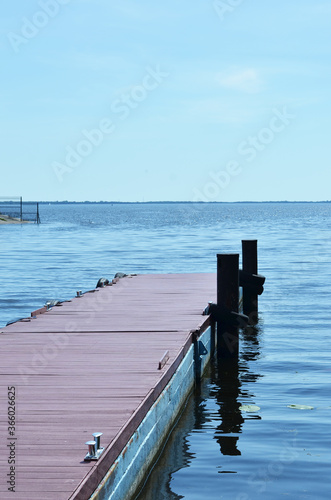 Wooden pier going into the water. Perspective view of a wooden pier on the seashore