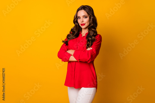 Photo of stunning fancy curly business lady bright pomade bossy person arms crossed wear office red shirt white trousers isolated yellow vibrant color background
