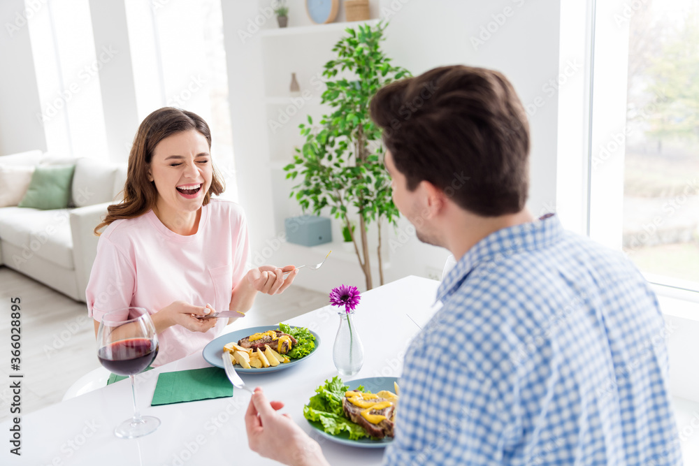 Portrait of his he her she two nice attractive lovely glad positive cheerful cheery spouses eating tasty yummy meal dish talking laughing in light white interior kitchen house apartment indoors