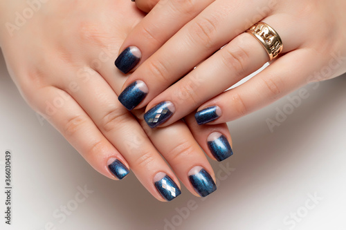 dark blue manicure on short square nails close-up on a white background with silver rhombuses on nameless nails